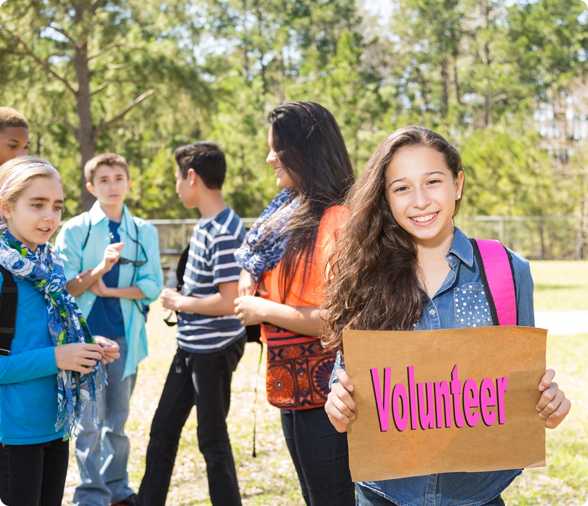 Teen girl holding "Volunteer" sign