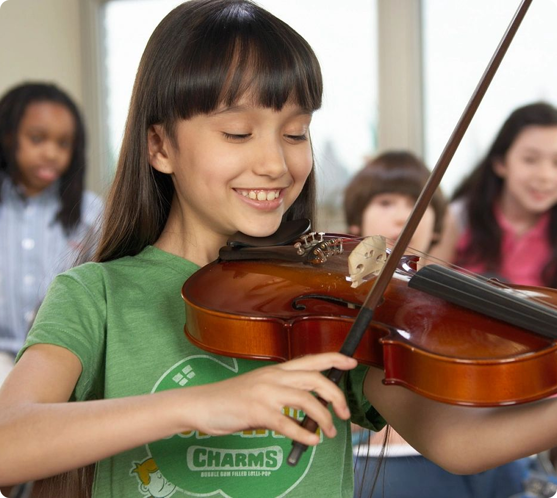 Girl playing violin in classroom