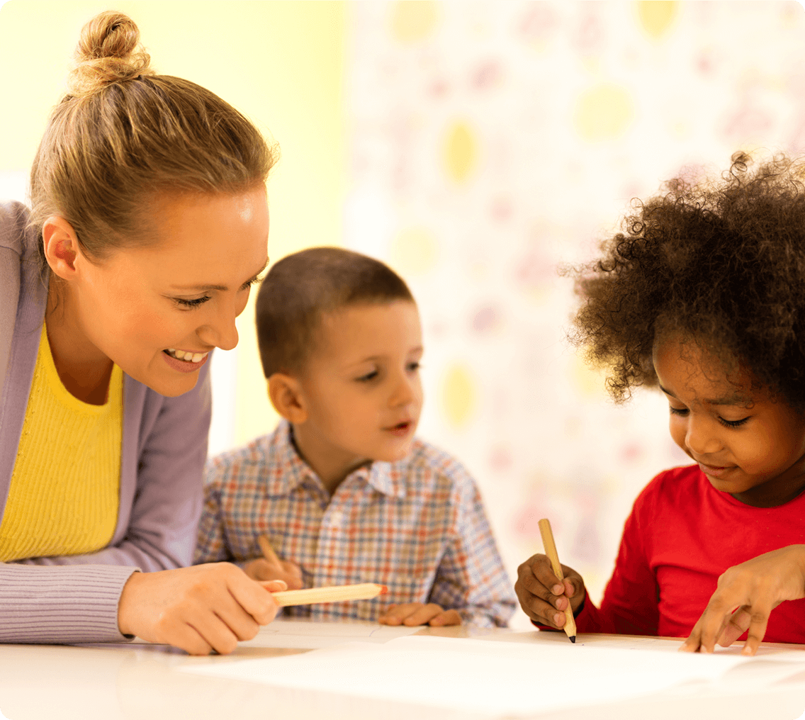 Kids coloring with teacher assistance