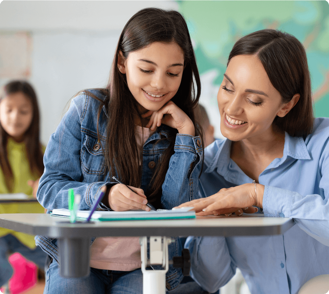 Smiling teacher assisting young girl