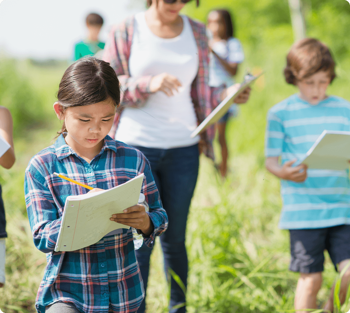 Kids exploring nature with notebooks