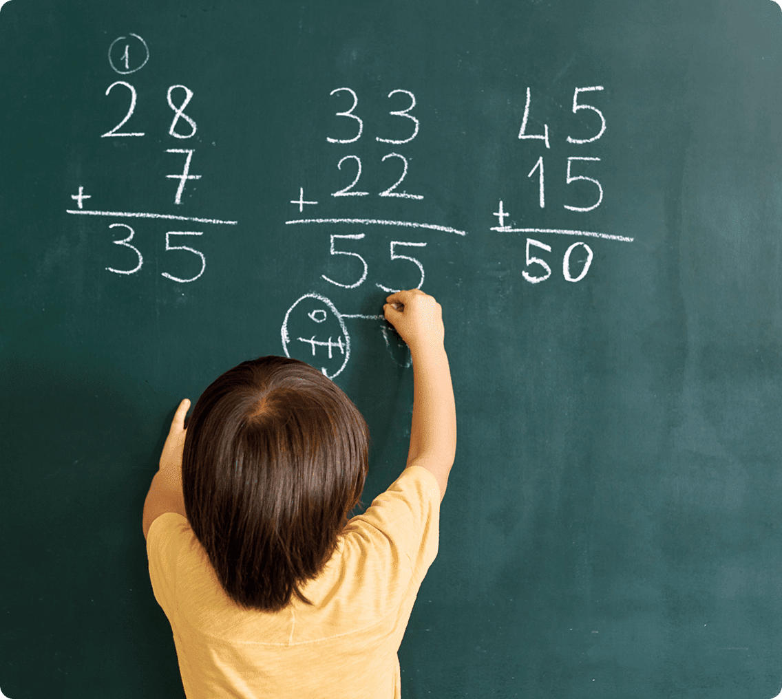 Kid practicing math calculations on chalkboard