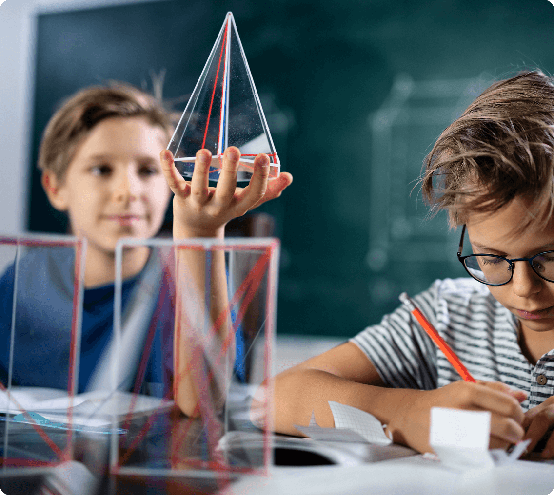 Boys learning geometry with clear pyramids