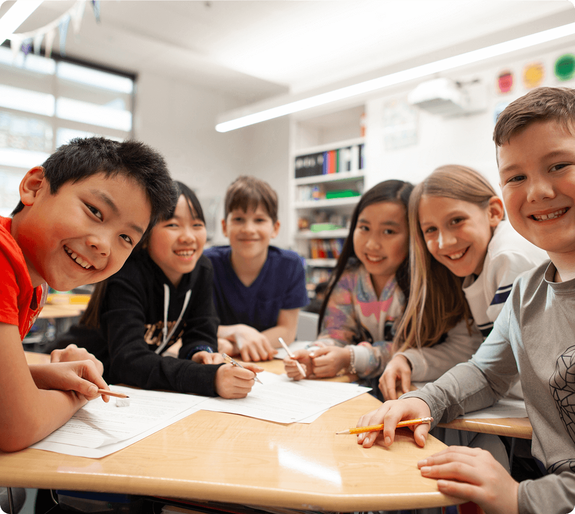 Happy children gathered around a desk