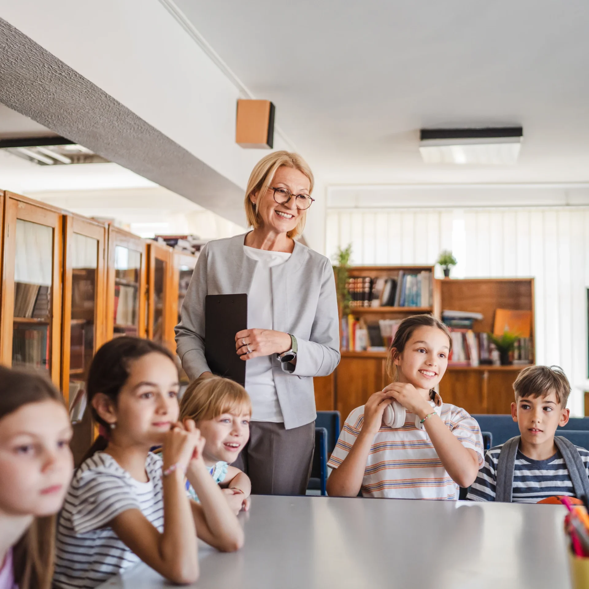 Teacher explaining a lesson to attentive students in a classroom.