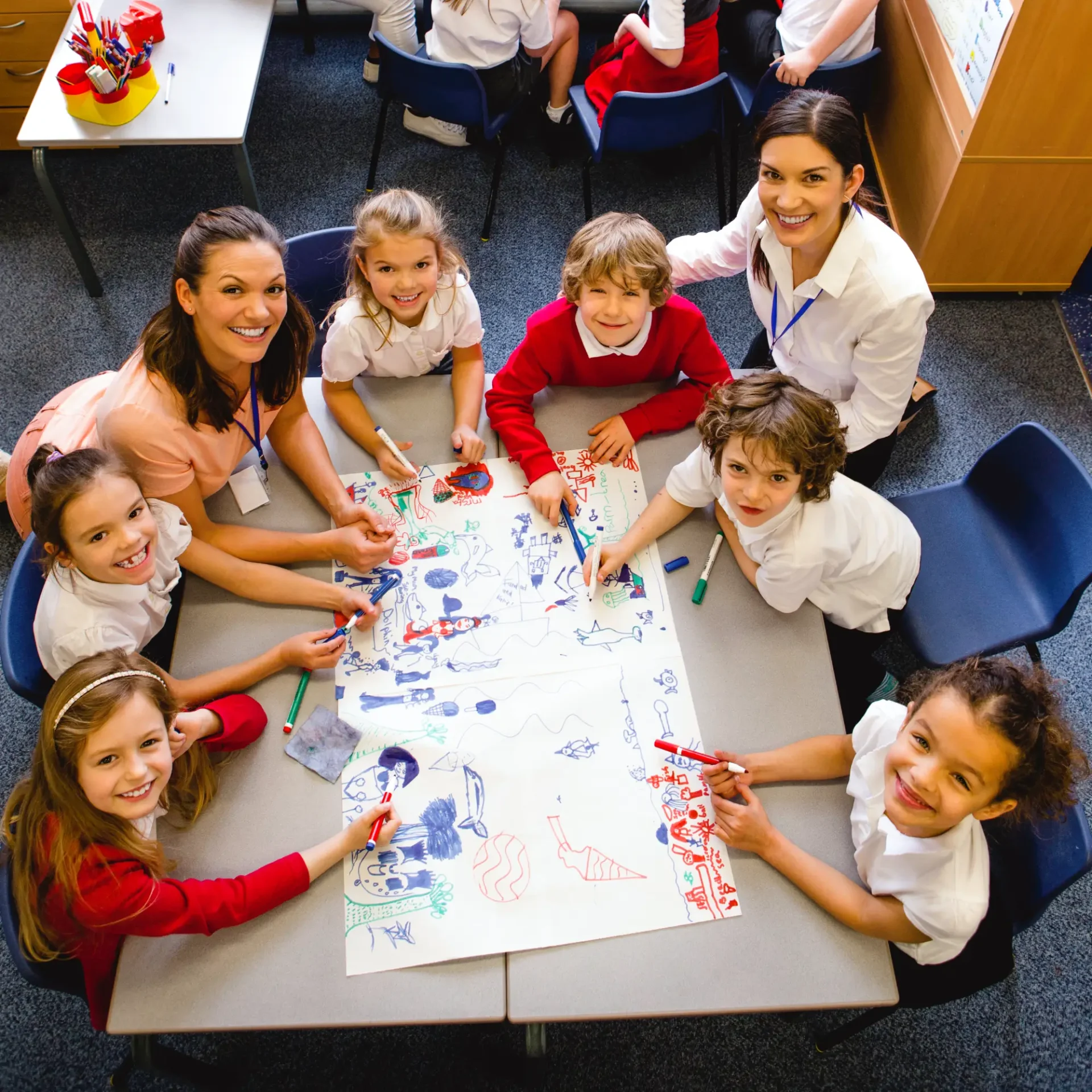 Children and adults gathered around a table doing arts and crafts.