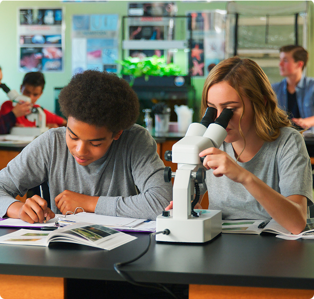 Students studying biology with a microscope