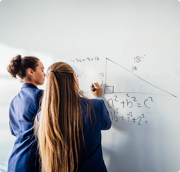 Students solving math problem on whiteboard