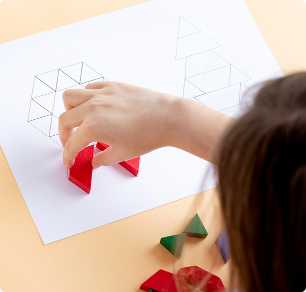 Hand arranging colorful 3D shapes