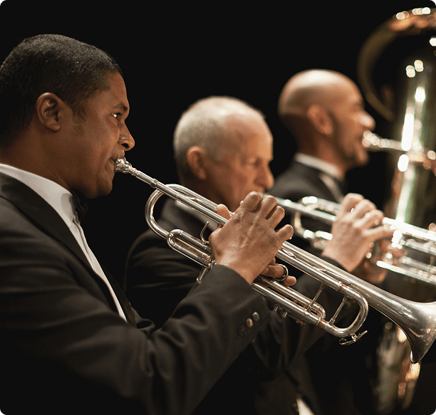 Musicians playing brass instruments in orchestra