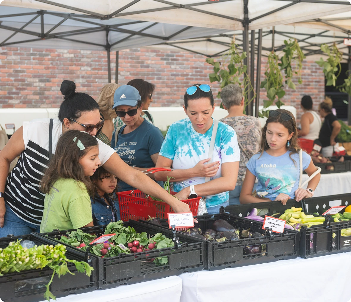Family selecting fresh produce at stall