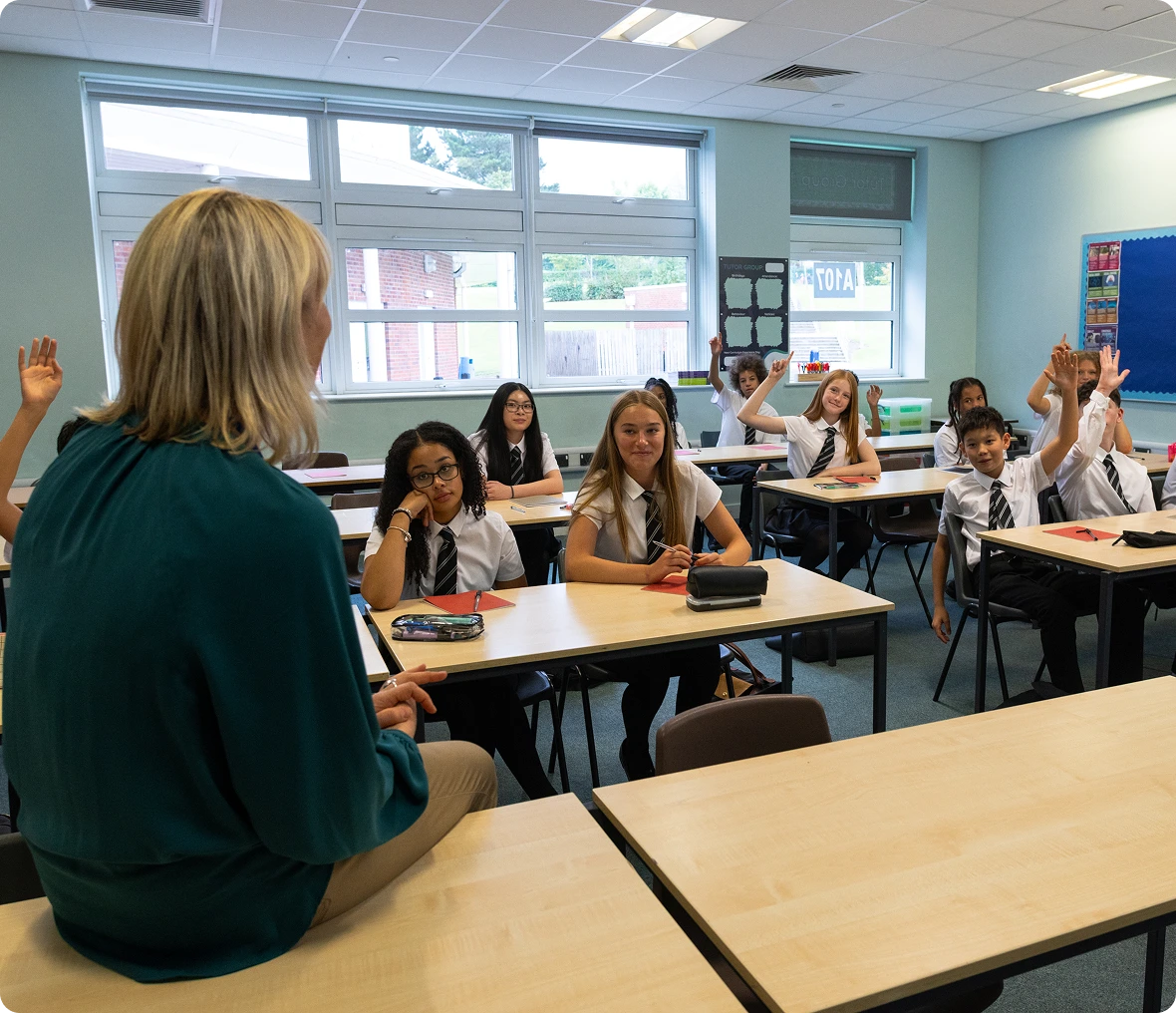 Students raising hands in a classroom