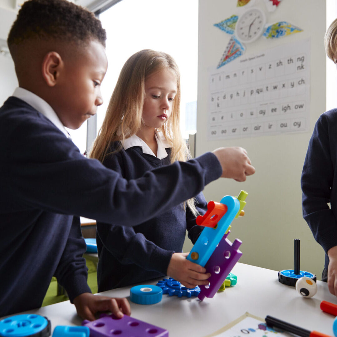Children collaborating on a colorful STEM project in a classroom.