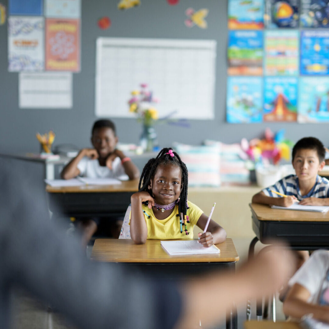 Young students attentively listening to their teacher in a classroom.