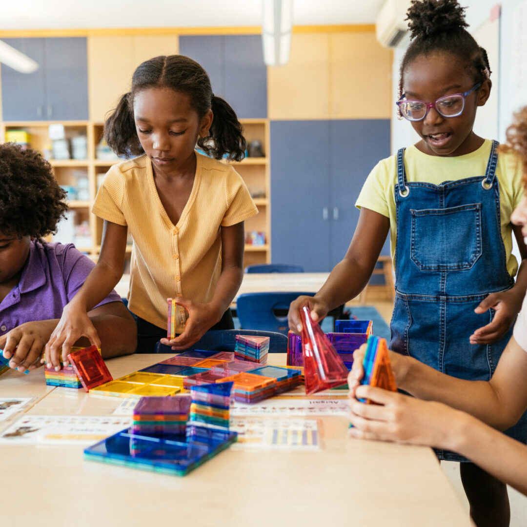 Children engaged in a colorful STEM activity with building blocks.