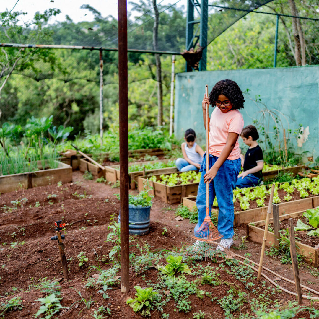 Woman gardening with children in a lush backyard.